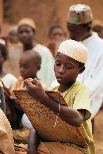 A young Muslim boy with writing materials 